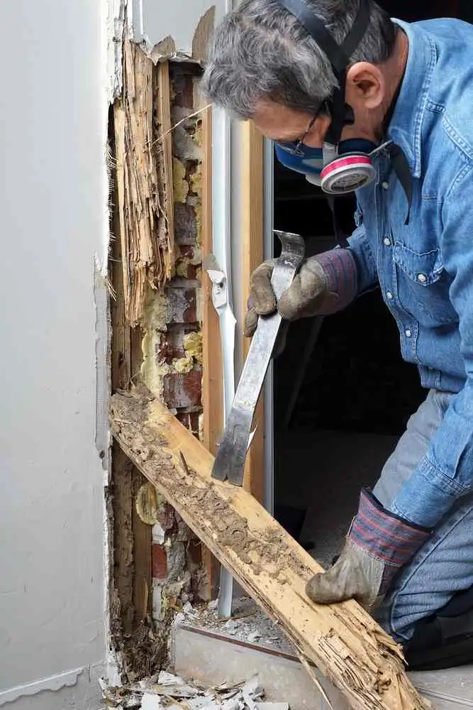 A man is removing wood from a door.